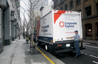 Corporate Express lorry on road with man at back