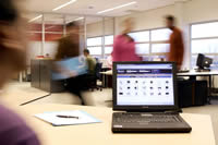 Laptop on a desk in a busy office