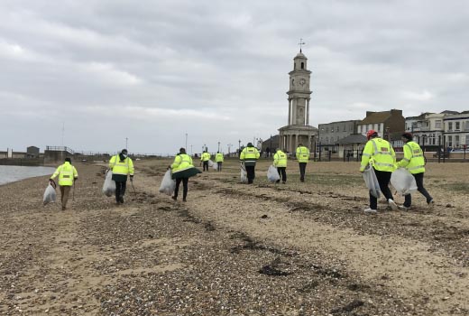 people tidying up on the beach