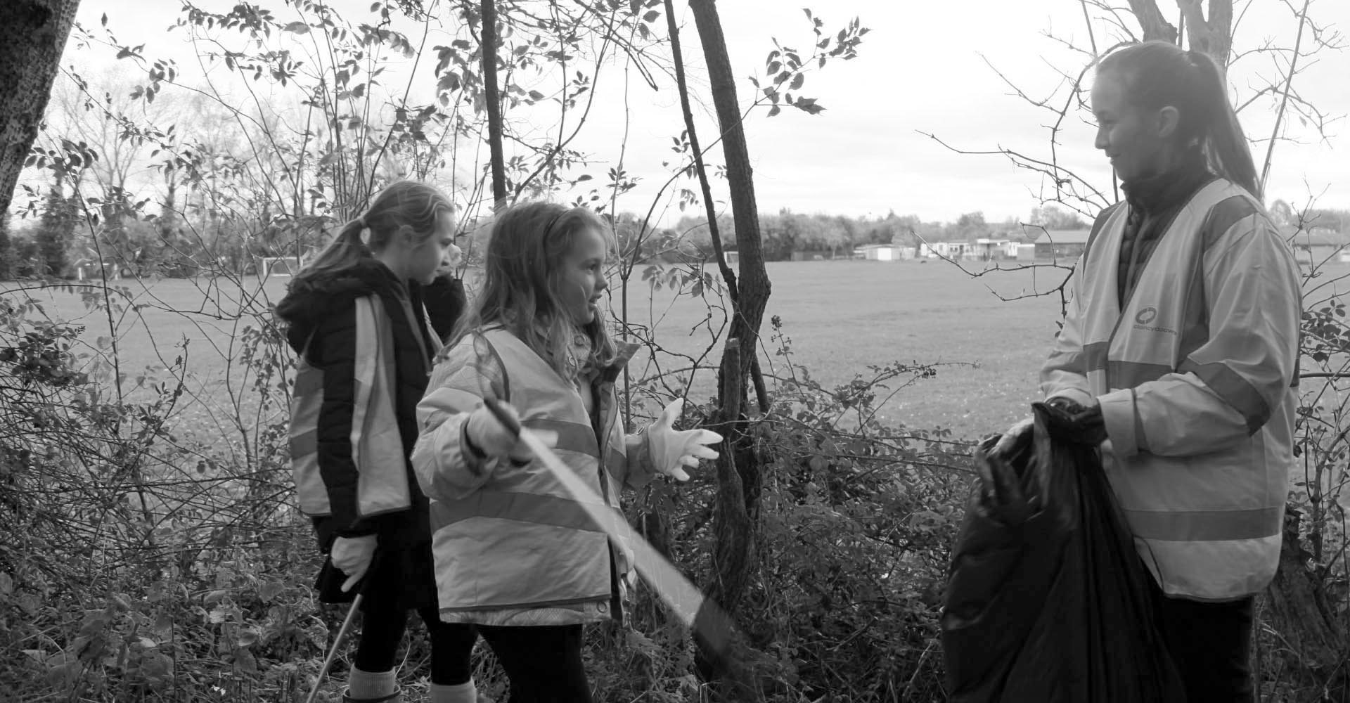 a group of children outside collecting rubbish