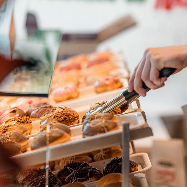 Using tongs to choose a donut