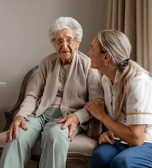An elderly woman and carer have a chat