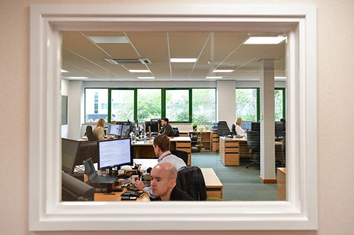 looking through a window at desk workers