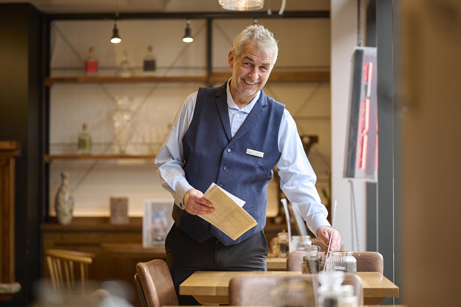 smiling man putting a menu on the table