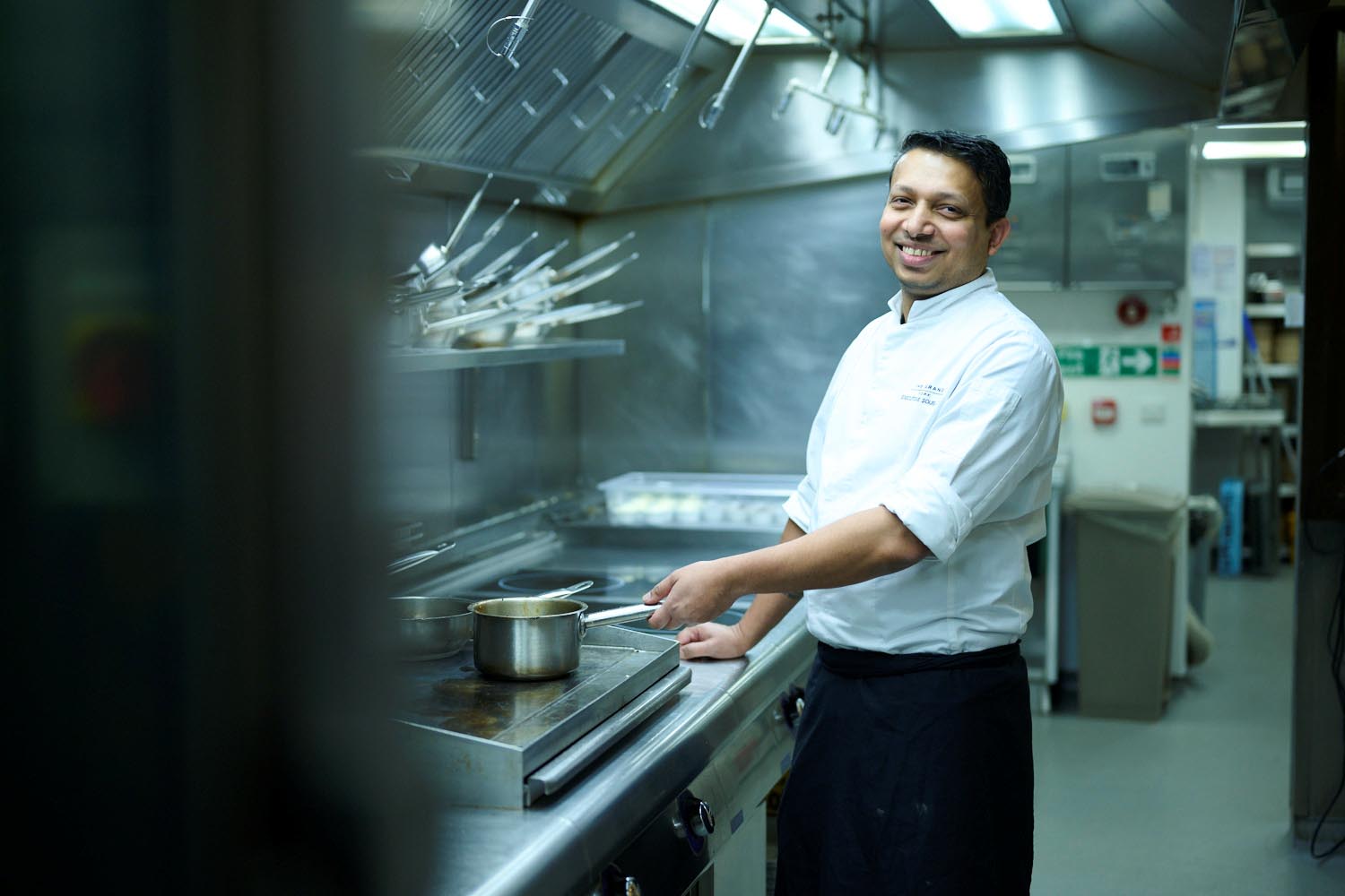 cook preparing sauce in a saucepan
